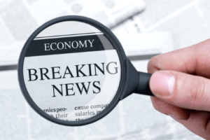 INVITATION TO SUBMIT COVID-19 TARGETED EIDL ADVANCE APPLICATION, Sensible Services ABC in Hammond La.; image of person's hand holding a black magnifying glass over a newspaper headline that reads "Economy, Breaking News"