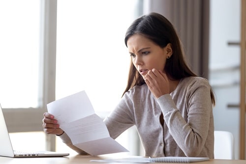 Audit Preparation and Representation for Audits of all Types in Hammond LA with Sensible Services ABC, image of young brunette woman reading a document with a worried look on her face with her left hand to her cheek