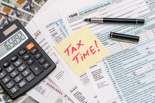 navigating tax season with professional accounting services through Sensible Services ABC. Image of calculator, tax papers and pen and a sticky note with tax season written in red.