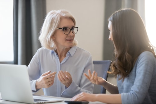 Bookkeeping services through Sensible Services ABC. Image of Two women working together at a desk with financial documents and a laptop, representing professional bookkeeping for startups